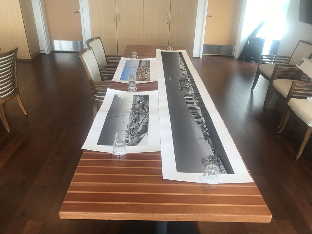 Three Panoramic Photos Laid Out on Tables in a Commercial Dining Room.
